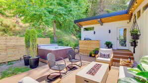 A wooden deck with outdoor furniture, a hot tub, and potted plants. - Whidbey Island Oasis: Walk to Beach, Hot Tub, View (Greenbank)