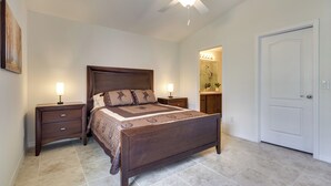 A bedroom with a bed, nightstands, a ceiling fan, and a door. - Lake Wales Vacation Rental Near Lake Kissimmee! (Lake Wales)