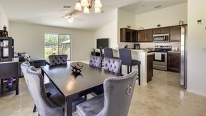 A modern kitchen with dark wooden cabinets, a stainless steel refrigerator, and a built-in microwave. - Lake Wales Vacation Rental Near Lake Kissimmee! (Lake Wales)