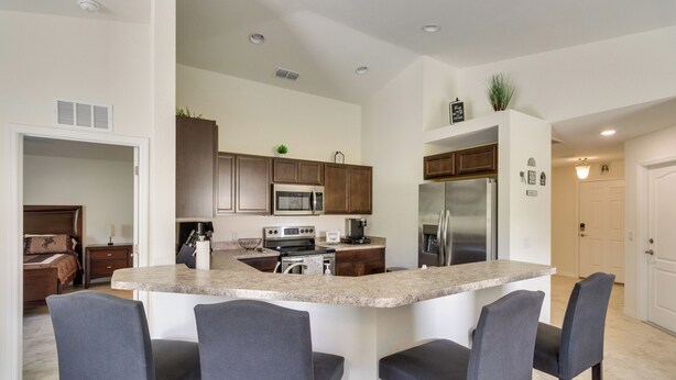 A modern kitchen with a central island, bar stools, and built-in appliances. - Lake Wales Vacation Rental Near Lake Kissimmee! (Lake Wales)