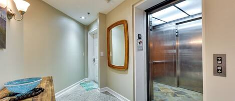 A hallway with a wooden table, a blue bowl, and a mirror on the wall.