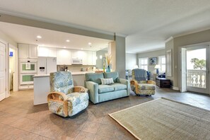 A spacious living area with a sofa, two armchairs, a coffee table, and a kitchen in the background. - Pet-friendly Fernandina Beach Condo: Walk to Beach (Fernandina Beach)