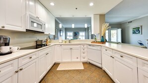 A modern kitchen with white cabinets, a microwave, and a coffee maker. - Pet-friendly Fernandina Beach Condo: Walk to Beach (Fernandina Beach)