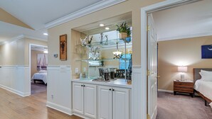 A bedroom with a bed, bedside table, lamp, and a nightstand. - Highend Pawleys Island Condo w/ Porch & Pools! (Pawleys Island)