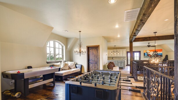 A spacious living room with a foosball table, a sofa, and a dining table. - Spacious Edmond Vacation Rental w/ Hot Tub! (Edmond)