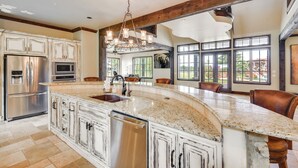 A spacious kitchen with a large island, stainless steel appliances, and a farmhouse-style ceiling. - Spacious Edmond Vacation Rental w/ Hot Tub! (Edmond)