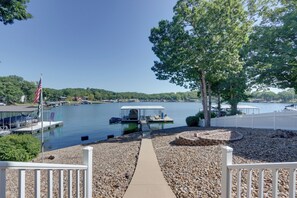 A lakeside view with a dock, boats, and a covered seating area. - Private Dock + 4 Decks: Lake Ozark Retreat! (Gravois Mills)