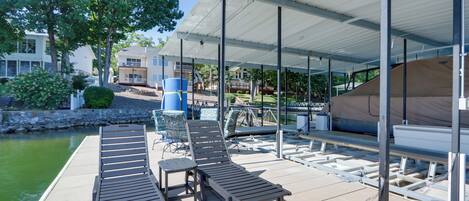 A covered outdoor area with lounge chairs and a poolside setting.