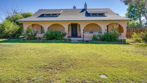 A two-story house with a gabled roof, a front porch with arches, and a well-maintained lawn. - Pet-friendly Pueblo Vacation Rental w/ Patio! (Pueblo)