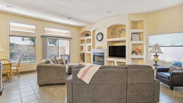 A living room with a fireplace, a TV, and a sofa. - Las Cruces Vacation Rental Near Trails & Golf! (Las Cruces)