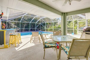 Un espace piscine intérieur doté de murs en verre, d’un ventilateur de plafond et de sièges disposés autour de la piscine.
