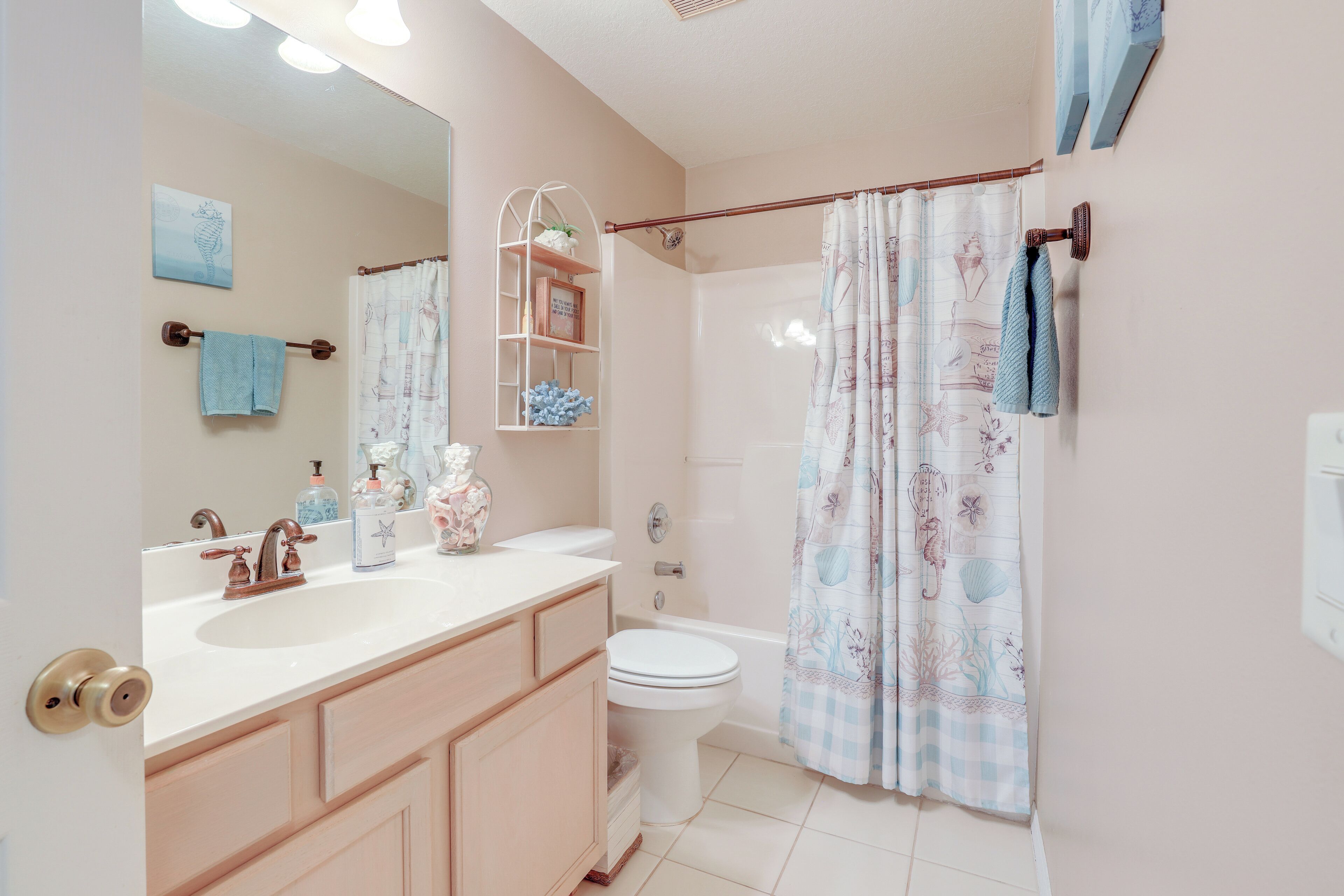 A bathroom with a sink, toilet, and shower curtain.