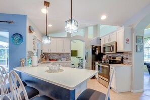 A modern kitchen with white cabinets, a central island, and stainless steel appliances. - Jensen Beach Home w/ Heated Pool! (Jensen Beach)