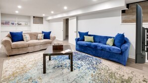 A modern living room with two sofas, a coffee table, and a patterned rug. - Cleveland Heights Retreat: Close to Everything! (Cleveland Heights)