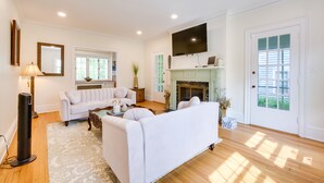 A spacious living room with a fireplace, a large flat-screen TV, and a cozy seating area. - Cleveland Heights Retreat: Close to Everything! (Cleveland Heights)