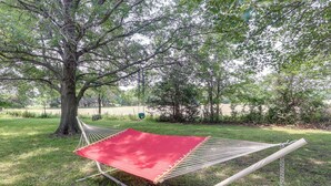 A hammock set up in a grassy area with a large tree nearby. - Coffeyville Countryside Studio w/ Fire Pit! (Coffeyville)