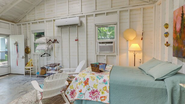 A cozy bedroom with a bed, a chair, a desk, and a window. - Coffeyville Countryside Studio w/ Fire Pit! (Coffeyville)