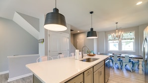 A modern kitchen with a large island, pendant lighting, and a view to the dining area. - Beaufort Getaway w/ Pool Access, 2 Mi to Downtown! (Beaufort)