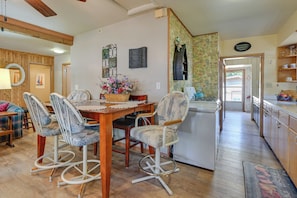 A dining area with a wooden table, chairs, and a refrigerator.
