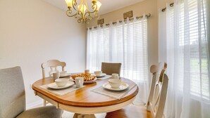A dining area with a round table, chairs, and a chandelier. - Family-friendly Spring Hill Vacation Home w/ Lanai (Spring Hill)