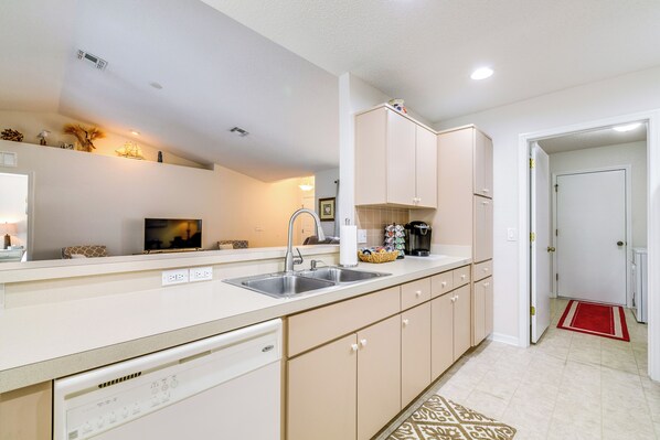 A modern kitchen with a dishwasher, double sink, and light-colored cabinets. - Family-friendly Spring Hill Vacation Home w/ Lanai (Spring Hill)