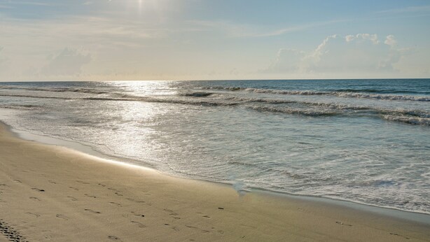 A beach with footprints in the sand and waves approaching the shore. - Ocean Access & Balcony: Surfside Beach Condo (Myrtle Beach)