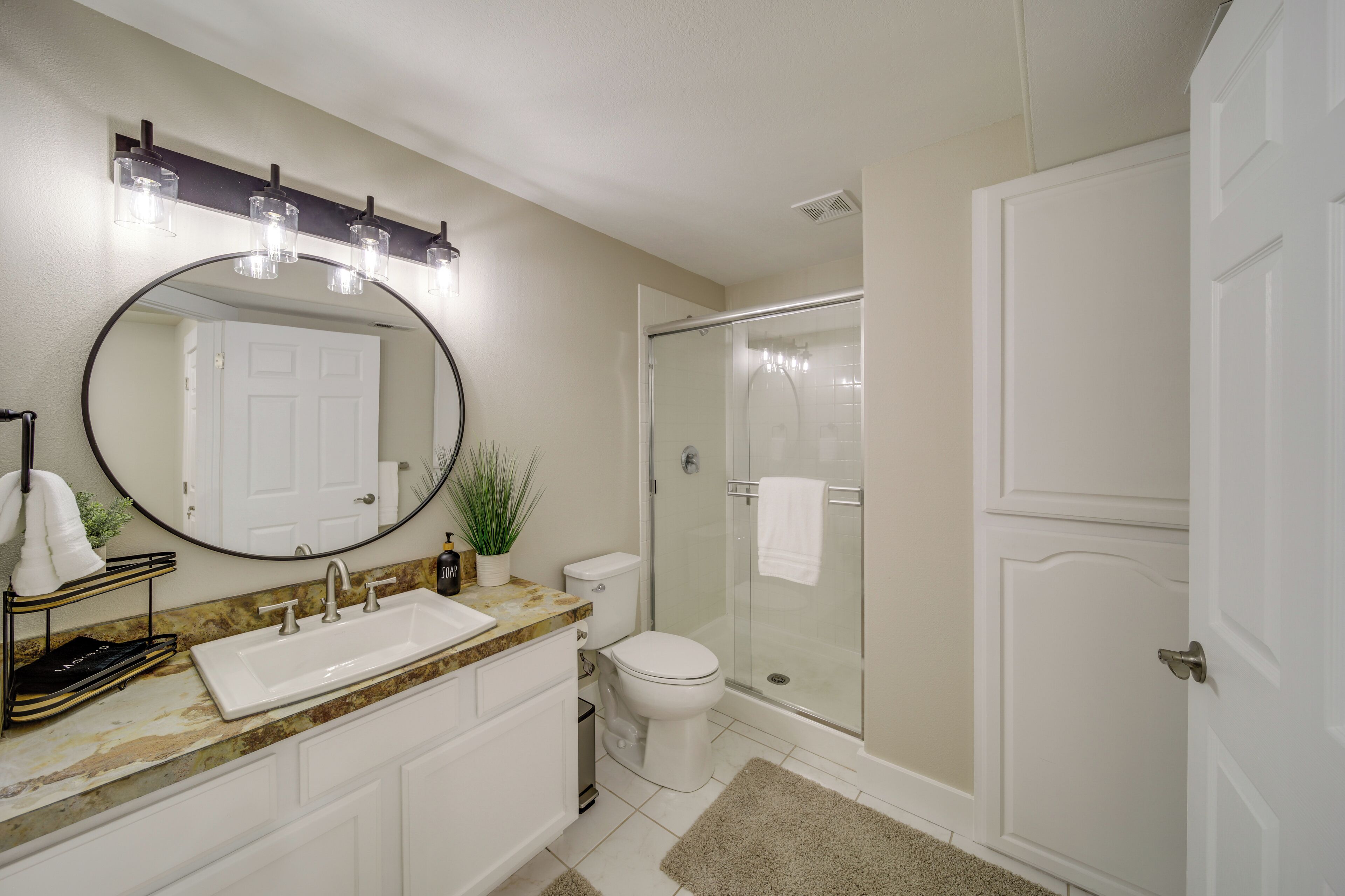 A bathroom with a sink, mirror, and toilet.