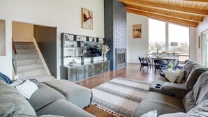 Ein geräumiges Wohnzimmer mit Kamin, einer Treppe und einem Essbereich.