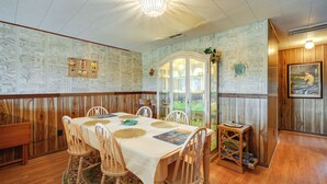 Un'area pranzo con tavolo in legno, sedie e un lampadario.