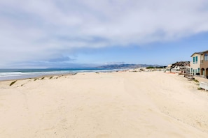 Uma praia com um edifício à direita.