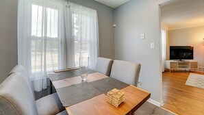 A modern living room with a sofa, a wooden coffee table, and a TV stand. - Pet-friendly Southfield House w/ Ping-pong Table! (Southfield)