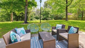 An outdoor seating area with wicker furniture and a lamp post. - Cozy High Point Vacation Rental: Near HPU Campus (High Point)