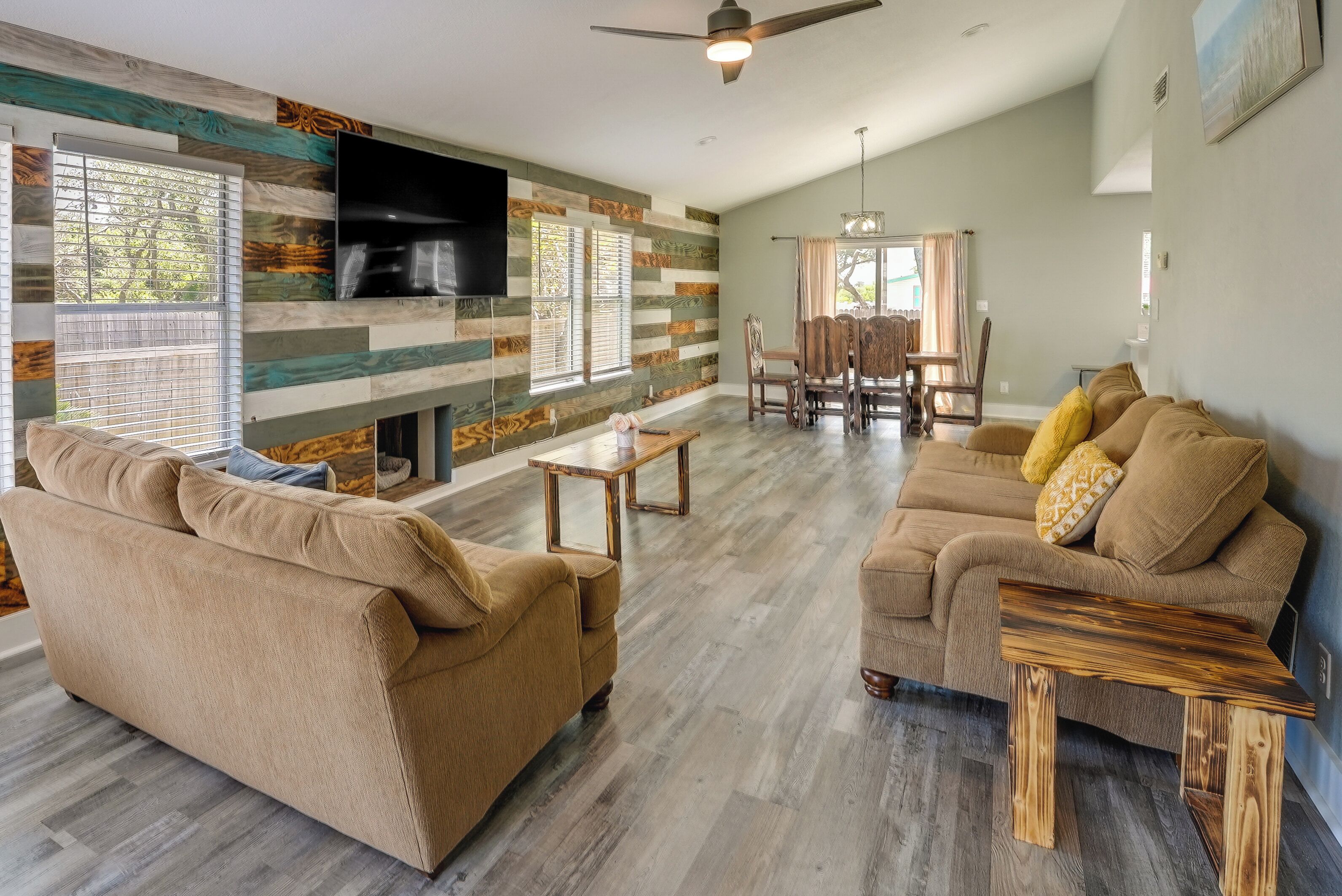 A spacious living room with a large sofa, a coffee table, and a dining area with chairs.
