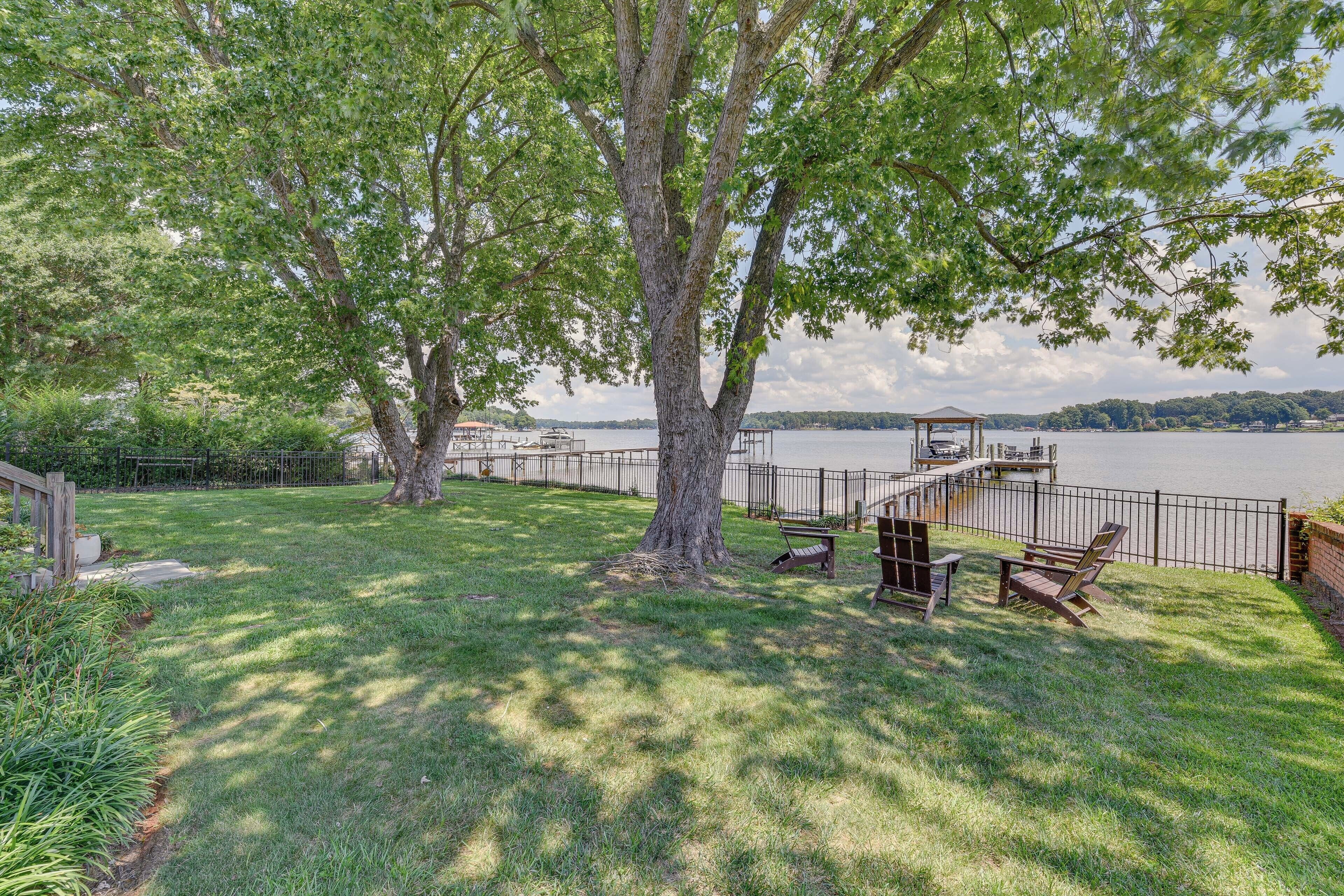Un parc au bord du lac, doté d’une terrasse en bois, de tables de pique-nique et de bancs.