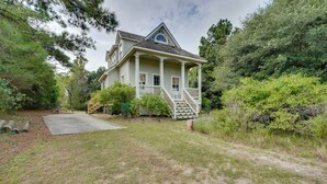 A two-story house with a porch, a front yard, and surrounding trees. - Charming Buxton Vacation Rental Near Beaches (Buxton)