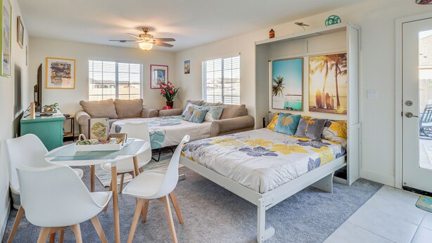 A bedroom with two single beds, a dining area with a table and chairs, and a ceiling fan. - Newly Built Sparks Home w/ Hot Tub: 12 Mi to Reno! (Sparks)