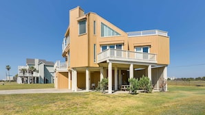 A modern two-story house with a covered porch and a balcony.