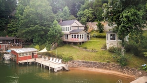 Une propriété au bord du lac comprenant une maison, un quai et une zone de baignade.