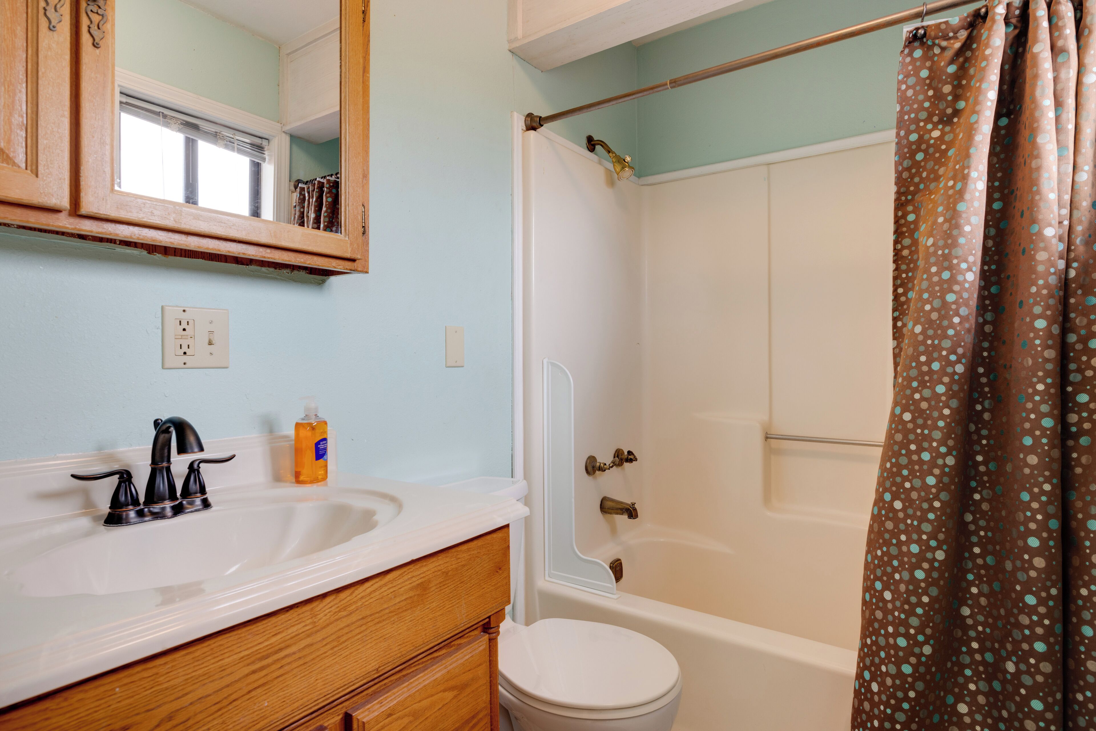 Un baño con lavabo, espejo, inodoro y bañera.