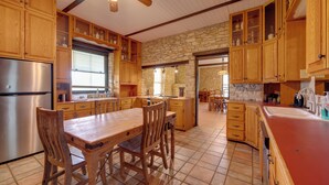 Una cocina amplia con armarios de madera, una isla central y una pared de piedra.