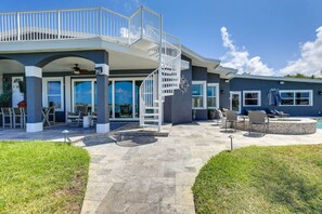 A modern house with a covered patio, outdoor seating, and a spiral staircase. - Luxury St. Petersburg Home w/ Pool + Bay Access! (St. Petersburg)