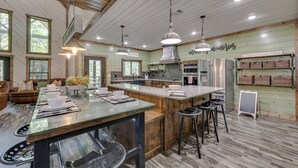 A spacious kitchen with a large island, modern appliances, and a rustic wooden ceiling. - Gorgeous Broken Bow Family Home w/ Private Hot Tub (Broken Bow)