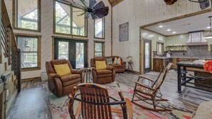 A spacious living room with high ceilings, a large fan, and a mounted deer head. - Gorgeous Broken Bow Family Home w/ Private Hot Tub (Broken Bow)