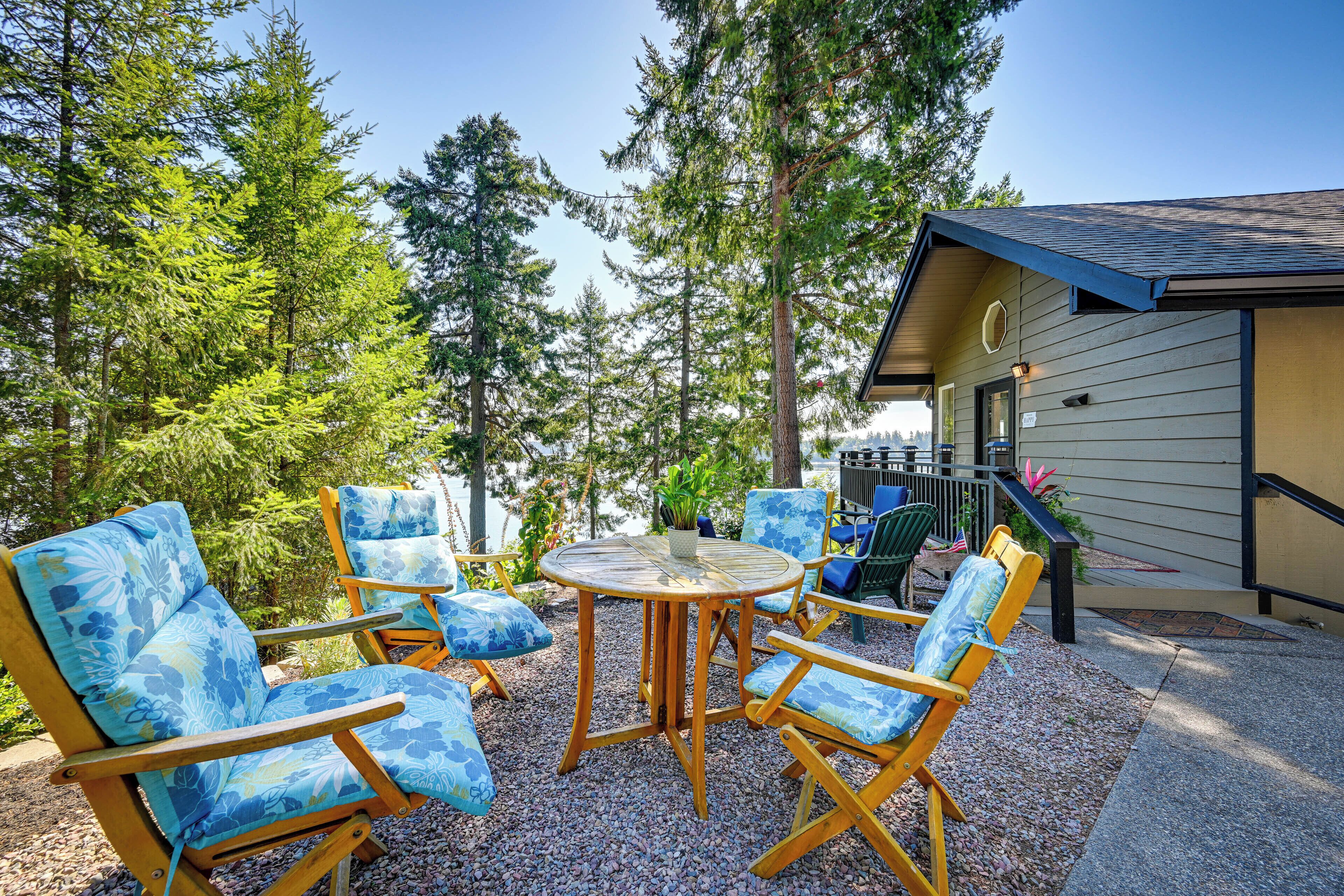 A patio with outdoor furniture and a view of a forested area.