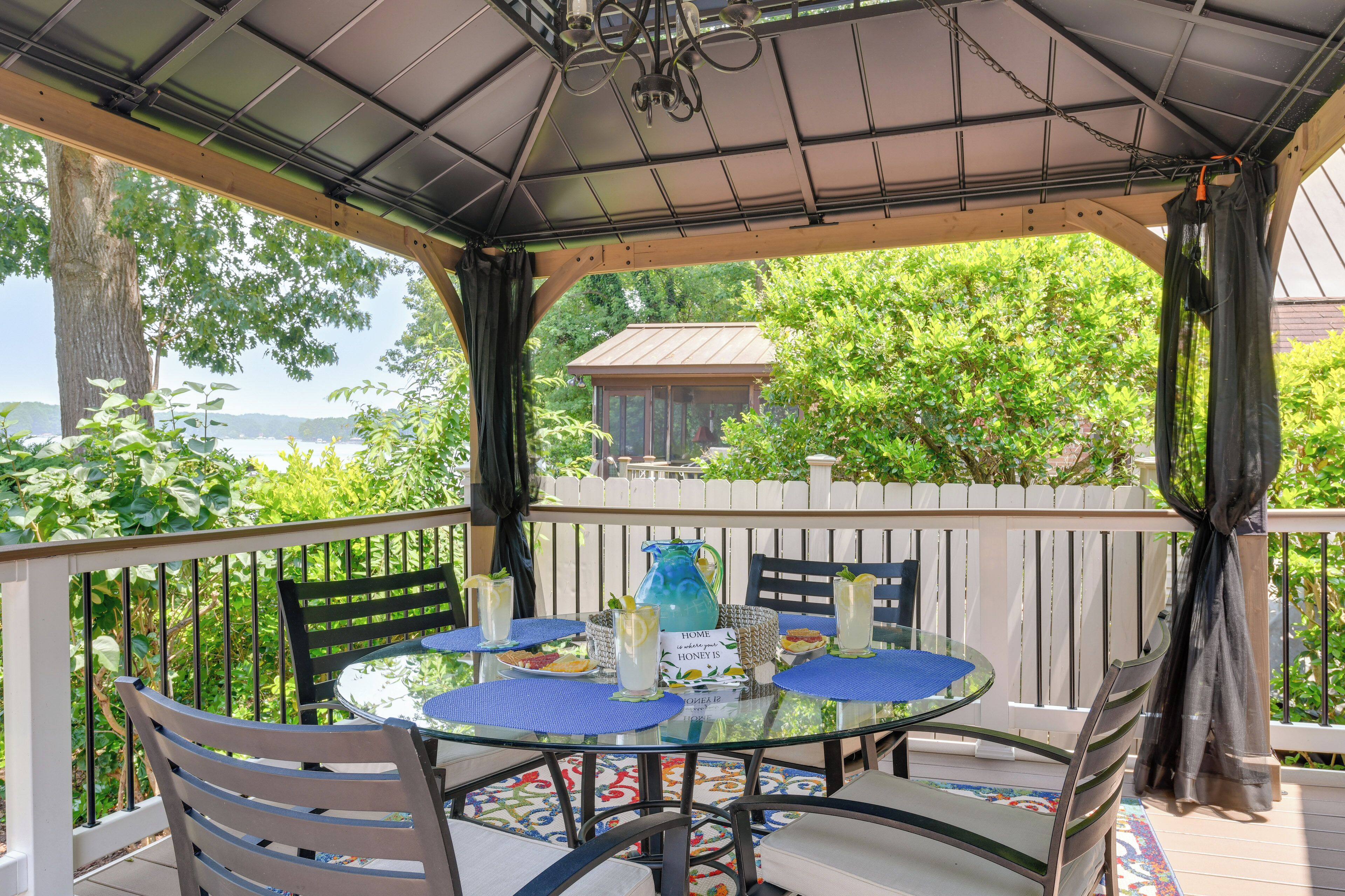 Une terrasse extérieure couverte, avec une table en verre, des chaises et une vue sur l’extérieur.