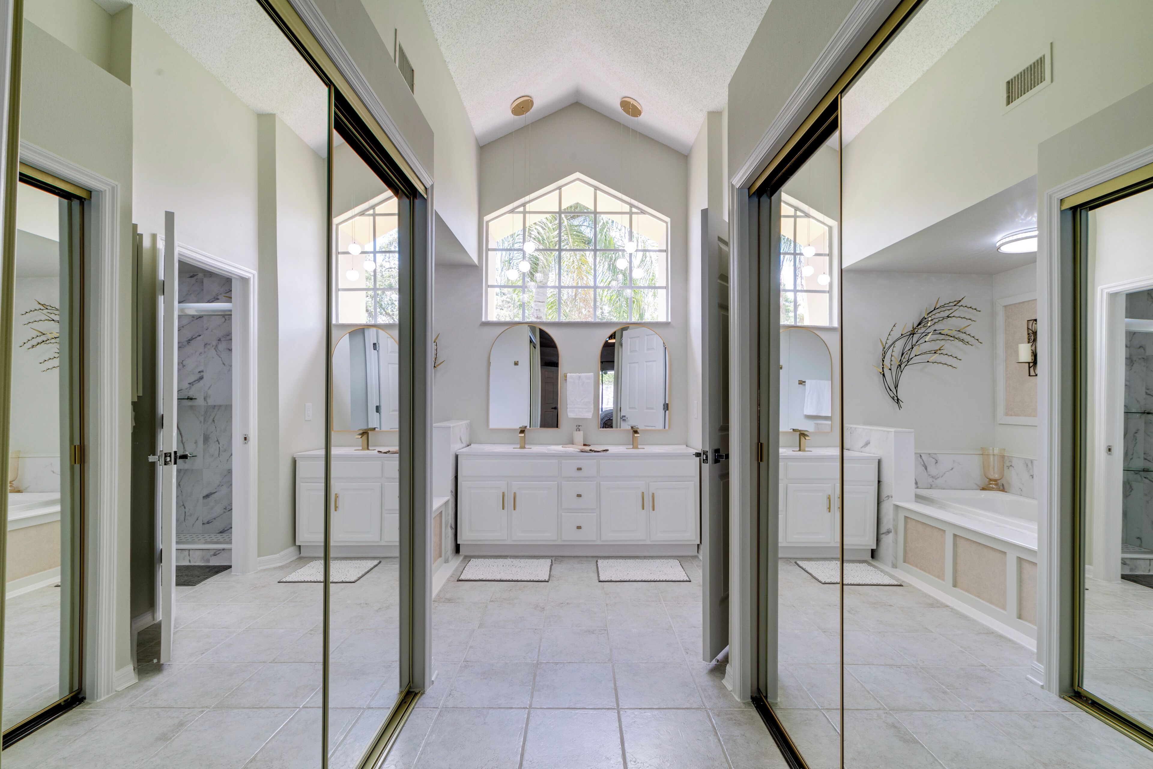 A spacious bathroom with a large vanity, two sinks, and a large window providing natural light.