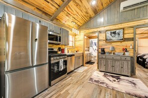 A modern kitchen with stainless steel appliances, wooden cabinetry, and a rustic ceiling. - Pet-friendly Broken Bow Cabin Near Lukfata Creek! (Broken Bow)