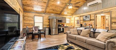 A cozy cabin interior with a dining area, kitchen, and living room.