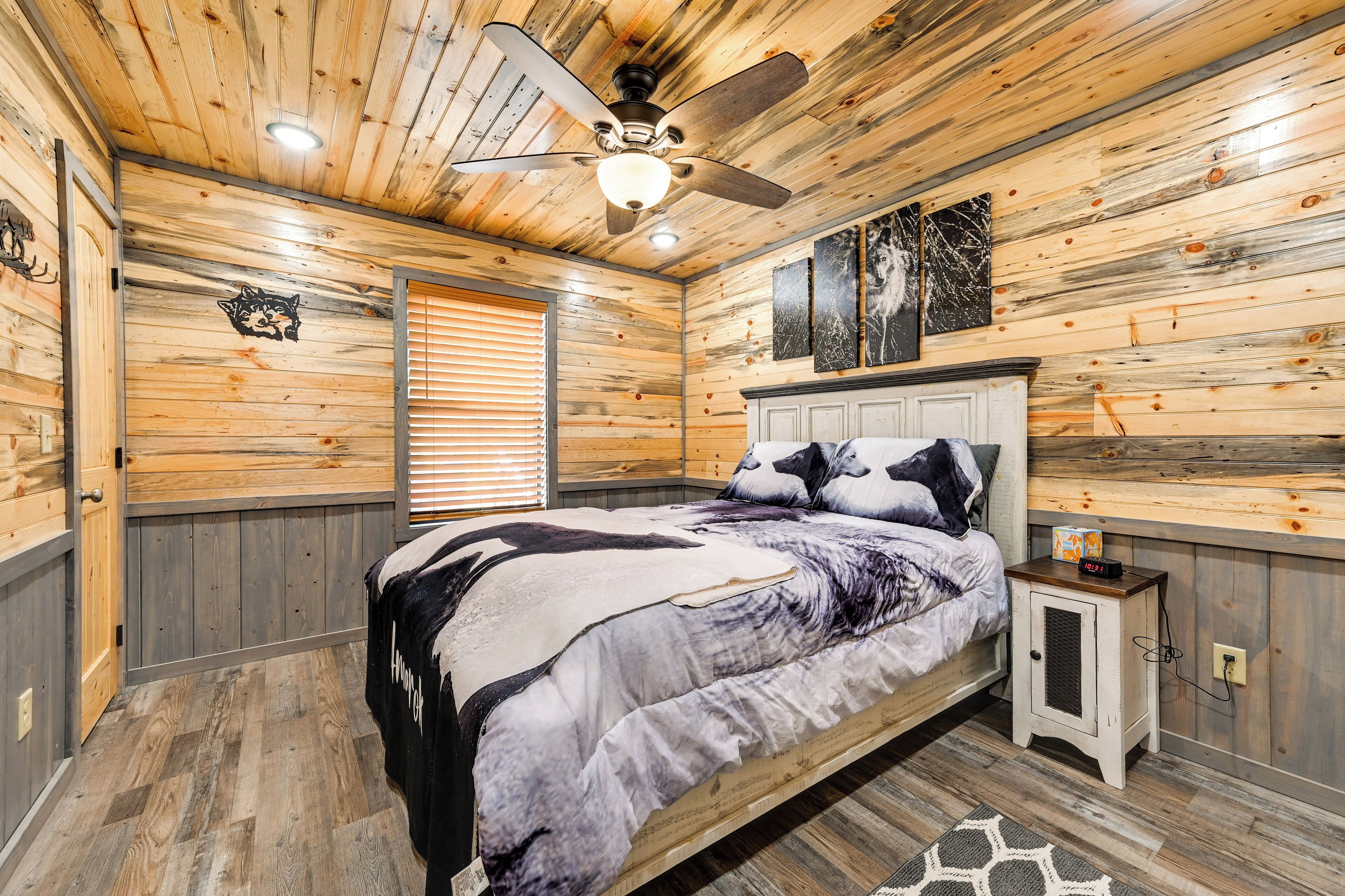 Un dormitorio con techo de madera, una cama con colcha de diseño blanco y negro, una mesita de noche con un reloj y una ventana con persianas.