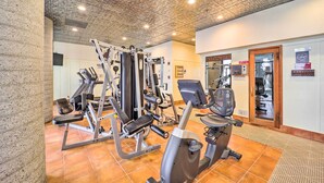 A gym with various exercise equipment, a large mirror, and a door leading to a waiting area. - Sugar Top Resort Condo w/ Heated Pool Access! (Banner Elk)